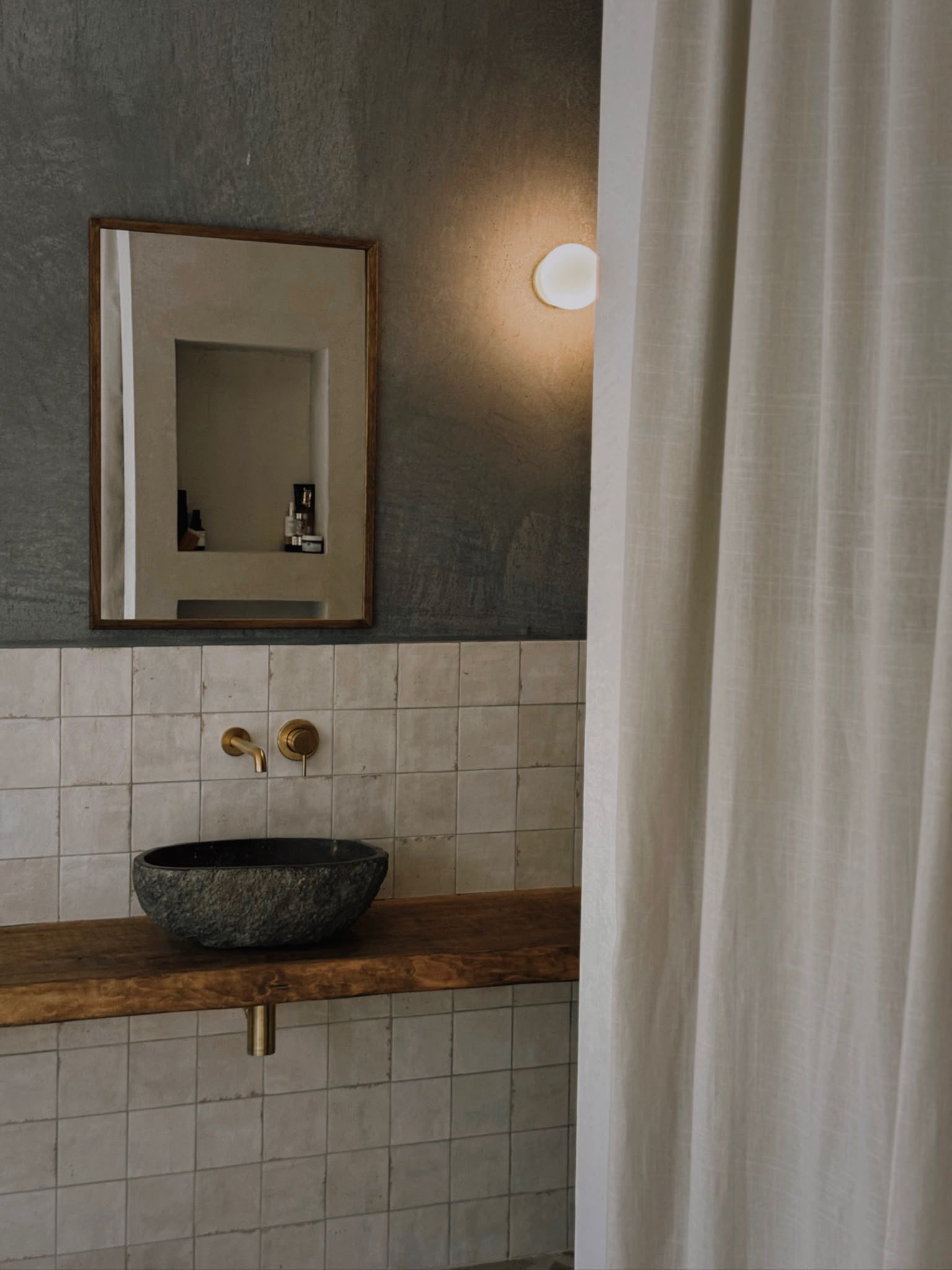 Badkamer met stenen waskom op een houten blad